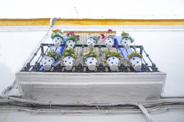 getünchter Balkon voller gepunkteter Blumentöpfe - Foto, Bild