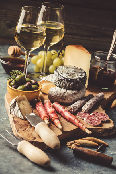 White wine with charcuterie assortment on the stone background - Foto, Imagen
