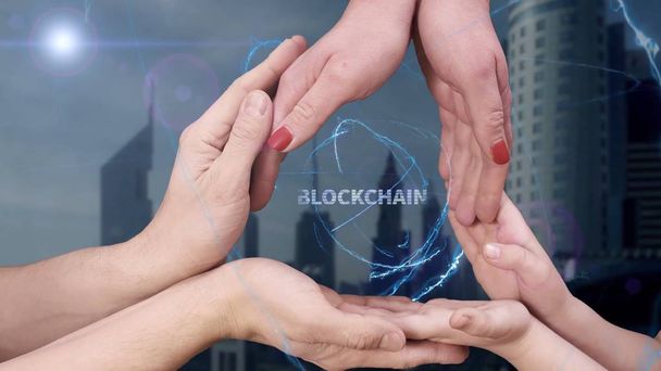 Mens, womens and childrens hands show a hologram Blockchain - Photo, Image