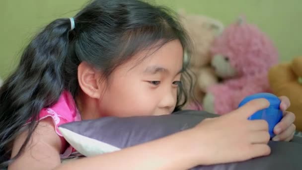Little asian girl play video game in living room. - Metraje, vídeo
