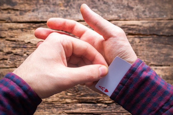 card sharper pulls an ace from the sleeve - Foto, imagen