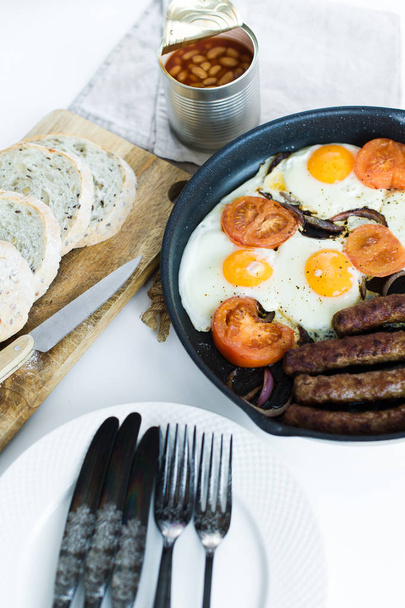 Англійський сніданок в сковороді на білому фоні. - Фото, зображення