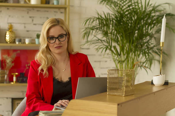 Красива блондинка бізнес-леді працює вдома на ноутбуці
. - Фото, зображення