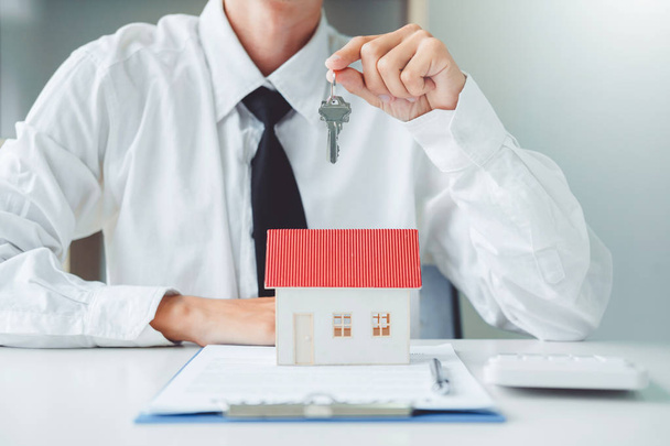Πώληση αντιπρόσωπος δίνοντας κλειδί σπίτι σε πελάτη και υπογραφή συμφωνία εισφορά - Φωτογραφία, εικόνα