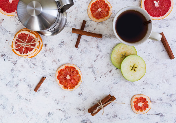 Фруктовый чай с яблоком, грейпфрутом и корицей на деревянном фоне
 - Фото, изображение