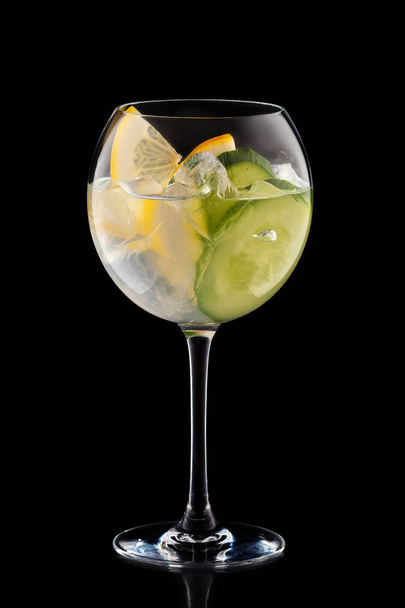 Big round wine glass with fresh cold lemonade isolated on black background - Foto, imagen
