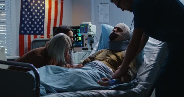 彼の家族の間で病院に横たわっている負傷した兵士 - 映像、動画