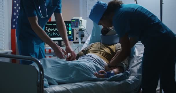 負傷した兵士が医師の間で病院に横たわっている - 映像、動画