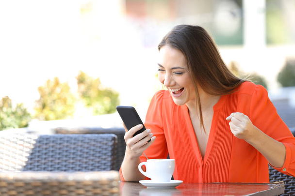 Захоплена жінка перевіряє вміст смартфона в кав'ярні
 - Фото, зображення