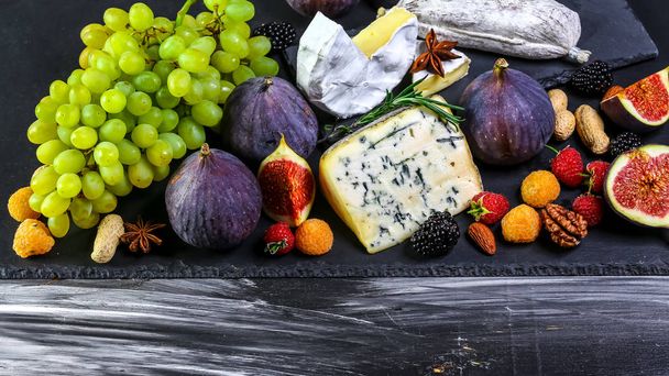 Meyveli peynir çeşitleri ve üzümler.eski tahta masanın üzerinde. üst görünüm. kopyalama alanı - Fotoğraf, Görsel