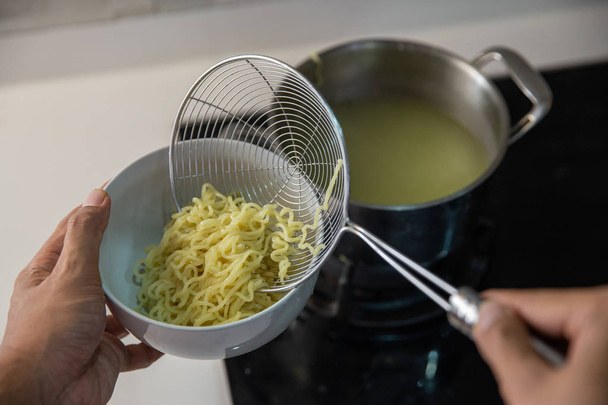 cooking instant noodle in the kitchen - Foto, afbeelding