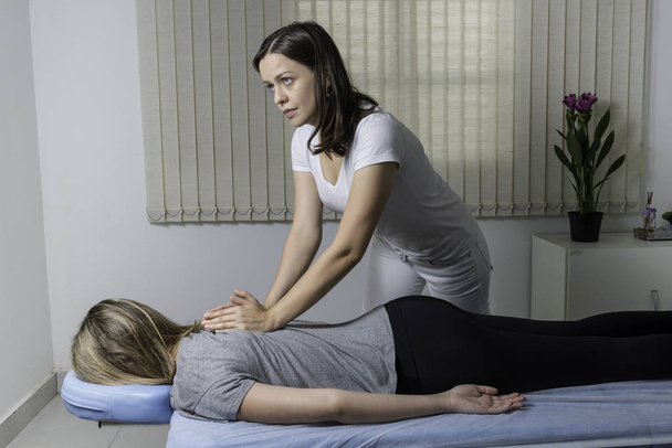 Blond Woman having chiropractic adjustment. Osteopathy, Alternative medicine, pain relief concept. Physiotherapy, sport injury rehabilitation. - Photo, Image