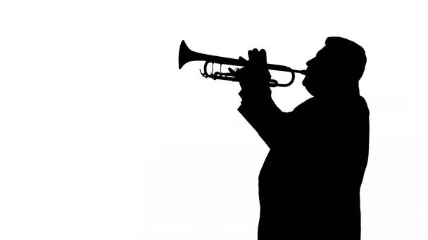 Mies siluetti pelaa trumpettia valkoisella taustalla
 - Valokuva, kuva