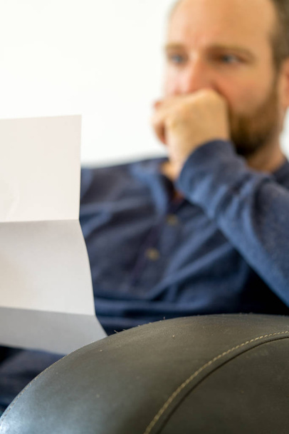 man reacting to bad news he receives in a letter selective focus - Photo, Image