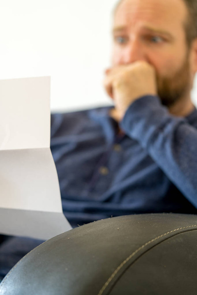 man reacting to bad news he receives in a letter selective focus - Photo, Image