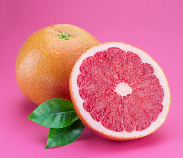 Grapefruit and grapefruit slice isolated on pink background. - Photo, Image