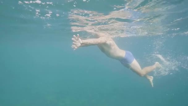 Unrecognizable man is swimming, underwater shot. - Záběry, video