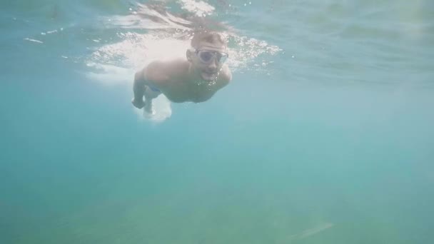 Man in mask is snorkeling in open ocean looking at wildlife, underwater shot. - Záběry, video
