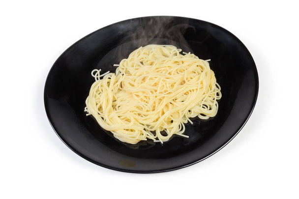 Pâtes spaghetti cuites sur un plat noir sur fond blanc
  - Photo, image
