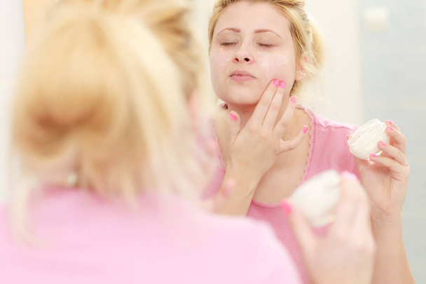 Woman applying face cream with her finger - Zdjęcie, obraz