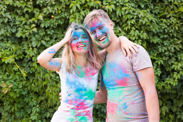 Friendship, festival of holi, people concept - young couple playing with colors at the festival of holi - Foto, afbeelding