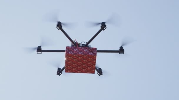 Nahaufnahme-Lens-Flare UAV-Drohne liefert Waren. Last-Minute-Geschenk-Lieferung per Frachtmulticopter. Versanddrohne bringt Geburtstagsgeschenk nach Hause. Futuristische Drohne fliegt Weihnachtsgeschenk über den Himmel - Filmmaterial, Video