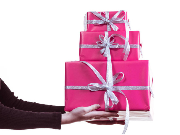 Female hands holding stack of pink gift boxes - Фото, зображення