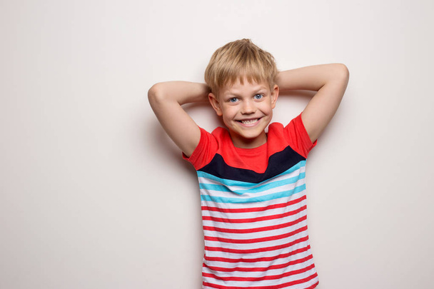 Little smiling boy in t-shirt isolated on white background. Studio portrait - Fotografie, Obrázek