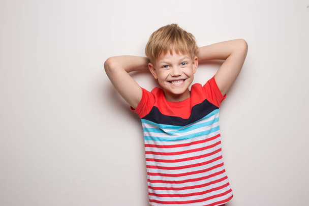 Little smiling boy in t-shirt isolated on white background. Studio portrait - Фото, изображение