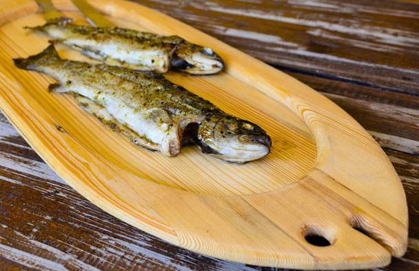 zwei gegrillte Fische auf einem Holzbrett - Foto, Bild