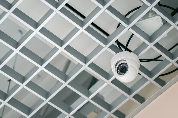 Surveillance camera on the lattice ceiling. Modern technologies. - Foto, afbeelding