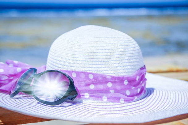 Stylish beautiful hat with cream on the seashore background - Foto, Imagen