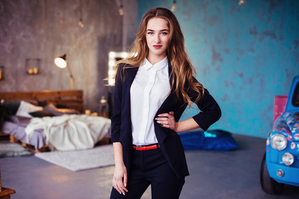 Young beautiful woman in a blue pantsuit in the interior. Business lady - Fotoğraf, Görsel