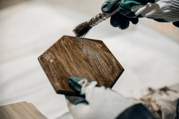 Trabalhador pinta um produto de madeira em marrom
. - Foto, Imagem