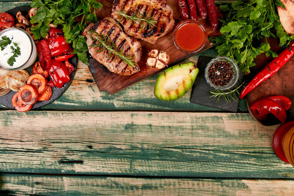 Steak pork grill on wooden cutting board with a variety of grilled vegetables - Фото, изображение