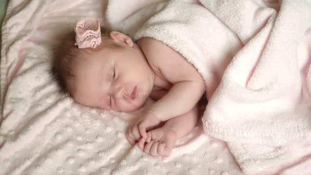 Yeni doğan küçük kız bebek yatakta uyuyor, küçük bebeğin tatlı rüyalar, sağlıklı uyku. - Video, Çekim