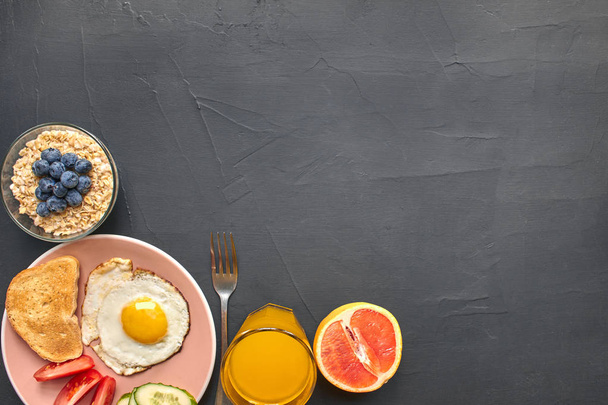 Top view of healthy and delicious breakfast on a black background with copyspace. - Photo, Image
