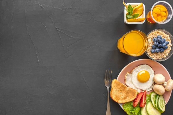Вид сверху на здоровый и вкусный завтрак на чёрном фоне с копирайтом
. - Фото, изображение
