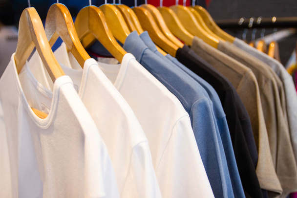 T-shirt πολύχρωμα στις κρεμάστρες για πώληση σε πολυκαταστήματα. - Φωτογραφία, εικόνα
