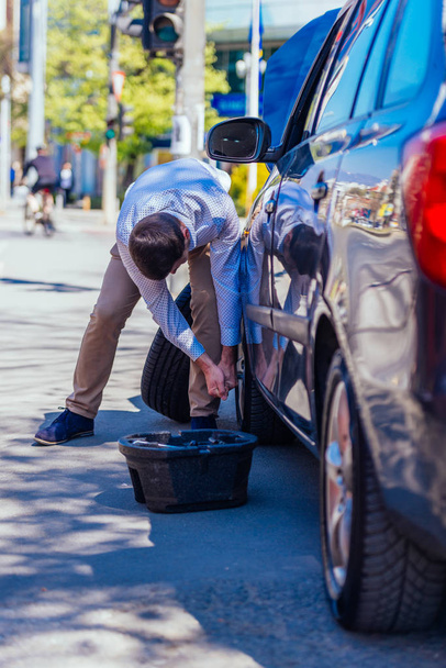 Um jovem empresário cansado suado está limpando o suor de seu fo
 - Foto, Imagem
