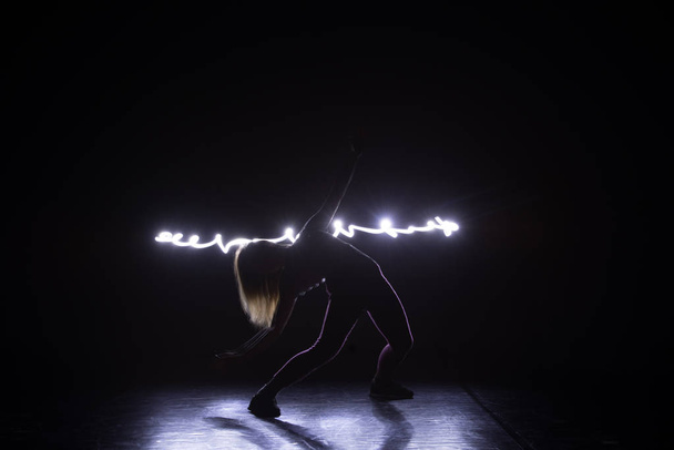 Танцовщица современного искусства, танцующая на черном фоне с n
 - Фото, изображение