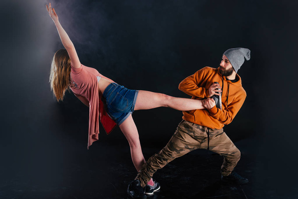 Couple dansant la danse moderne et montrant leur jambe étirer mo
 - Photo, image