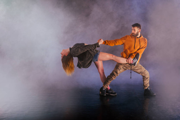 Pár táncoló modern tánc és mutatja ki a lábát nyúlik Mo - Fotó, kép