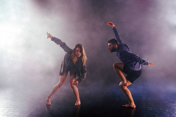 Two modern dancers stretching their shoeless feet high in the ai - Photo, Image