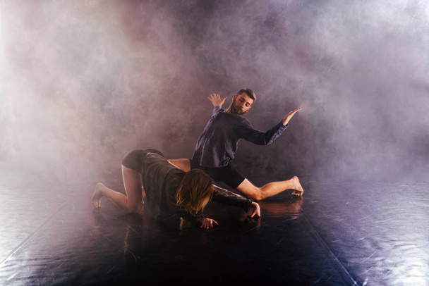 Modern dance couple twisting their legs and lening close to the  - Photo, Image