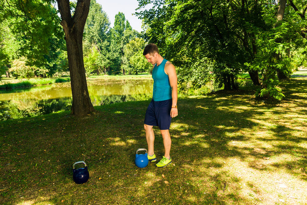 Фитнес-человек готовится к физическим упражнениям с гирями
 - Фото, изображение