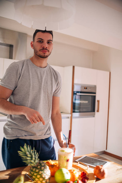 Hombre vegano en sus 20 años tiene una preparación de la mañana de un batido wh
 - Foto, imagen