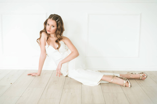Beautiful young girl in trendy white clothes in a bright studio - Foto, Bild