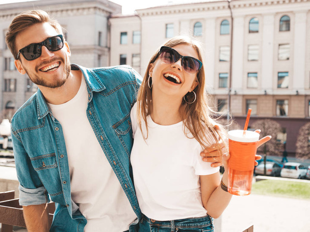 Smiling beautiful girl and her handsome boyfriend in casual summer clothes. Happy cheerful family having fun on the street background in sunglasses - Fotó, kép