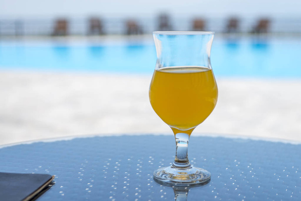 vidro de suco de laranja ou abacaxi fresco à beira da piscina
 - Foto, Imagem